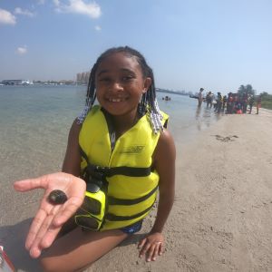 Young girl holding a hermit crab during a marine lab field trip