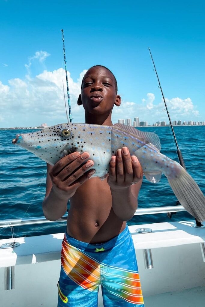 Young student with a fish he caught off Palm Beach.