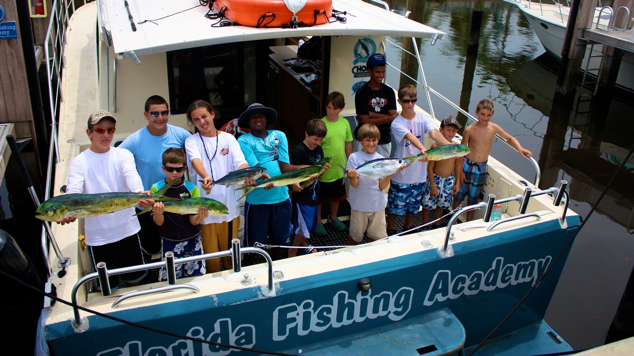 Youth with their fishing catches on the boat for nonprofit Florida Fishing Academy.